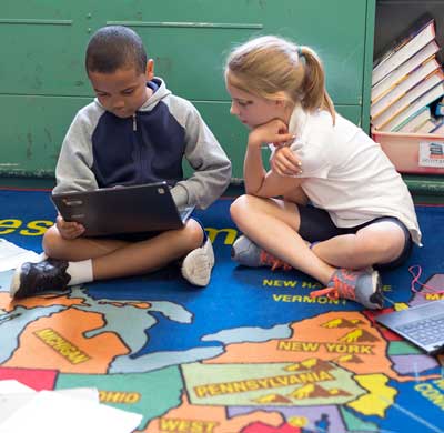 Children working on a laptop in a classroom