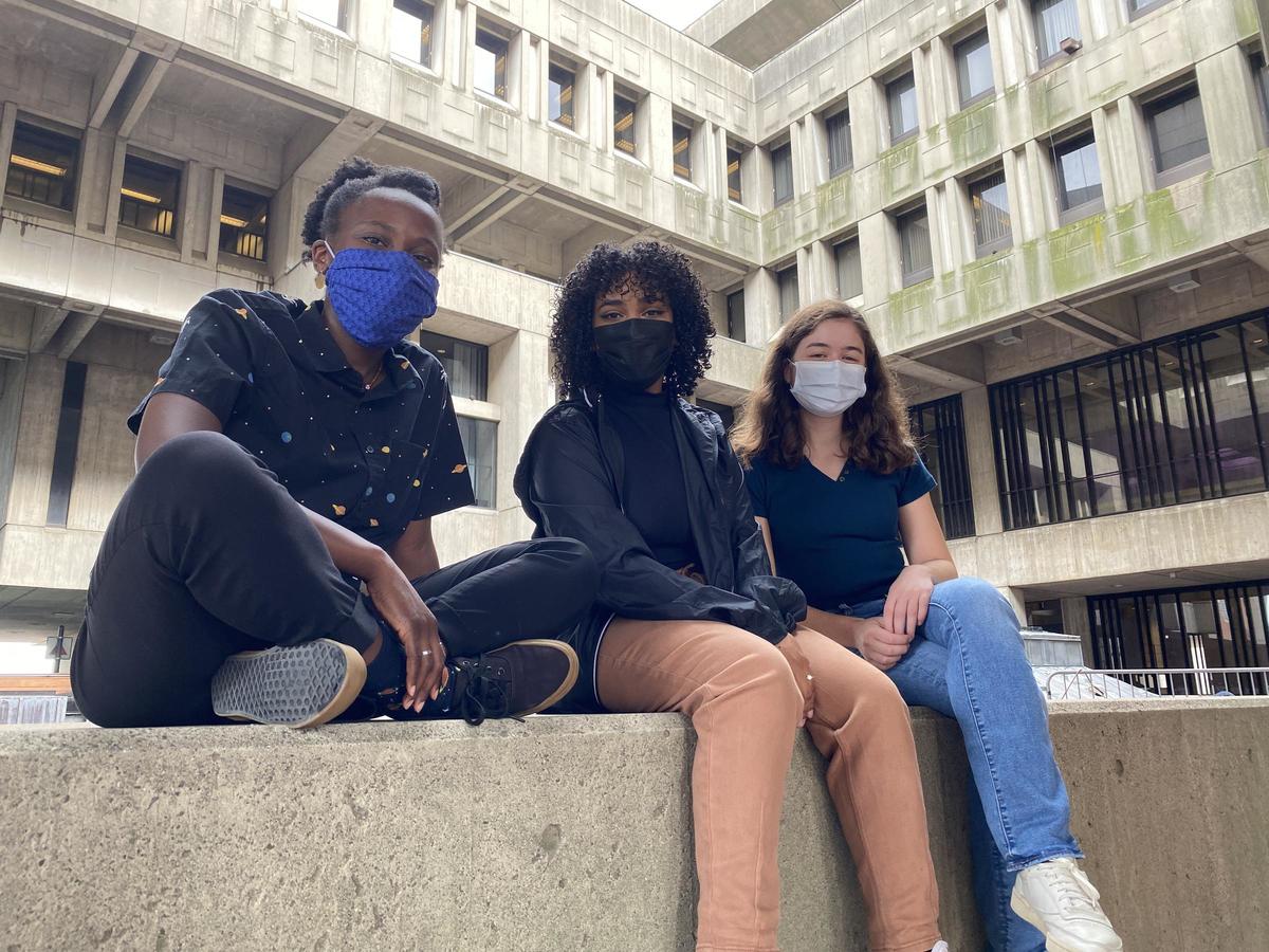 Three people sitting in city hall's courtyard