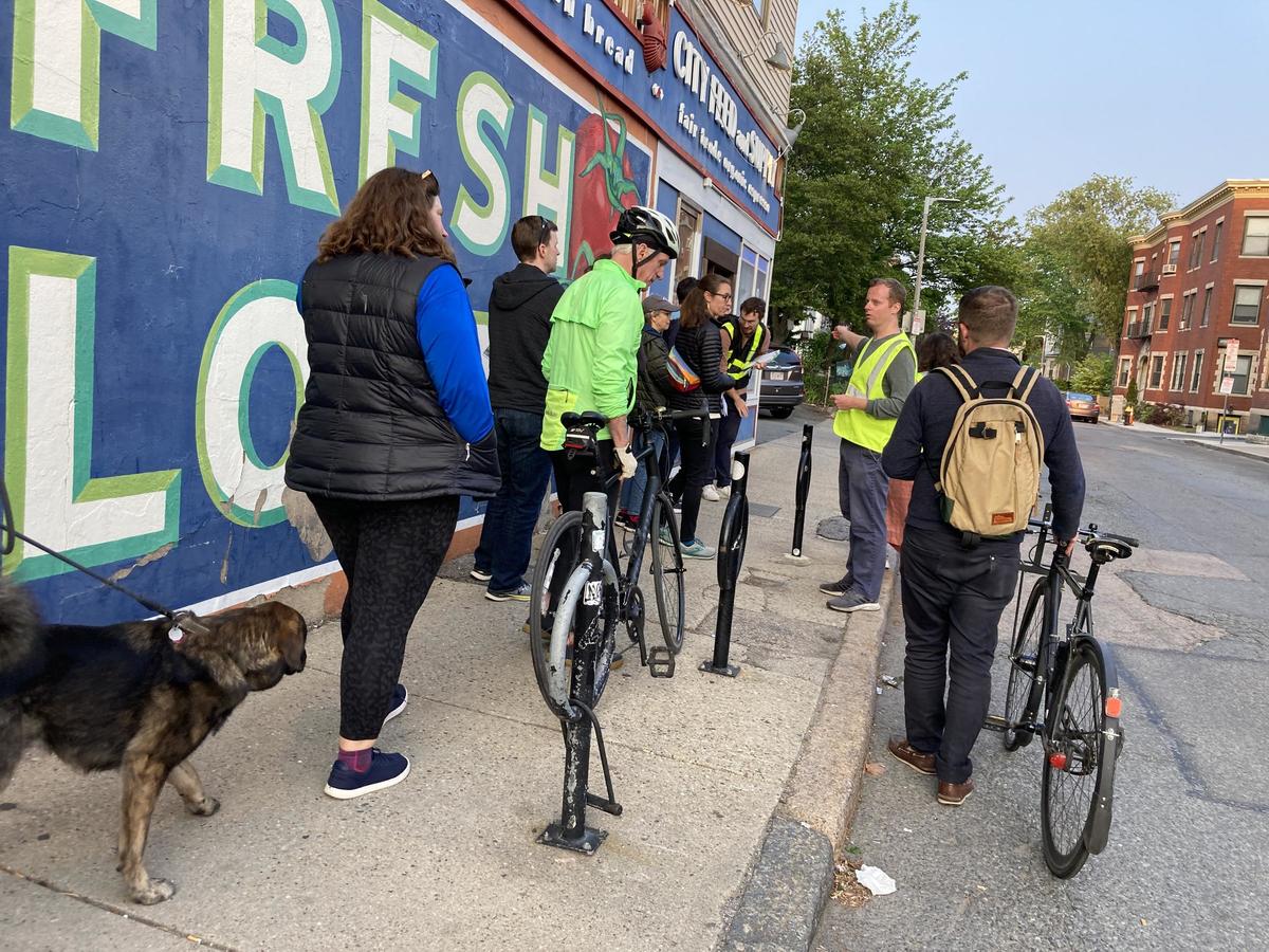 A BTD engineer talks to constituents about changes coming to Green Street and Seaverns Avenue in front of a mural.