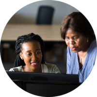 An intern and her mentor work together on a computer