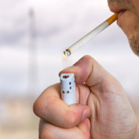 Person lighting up a cigarette